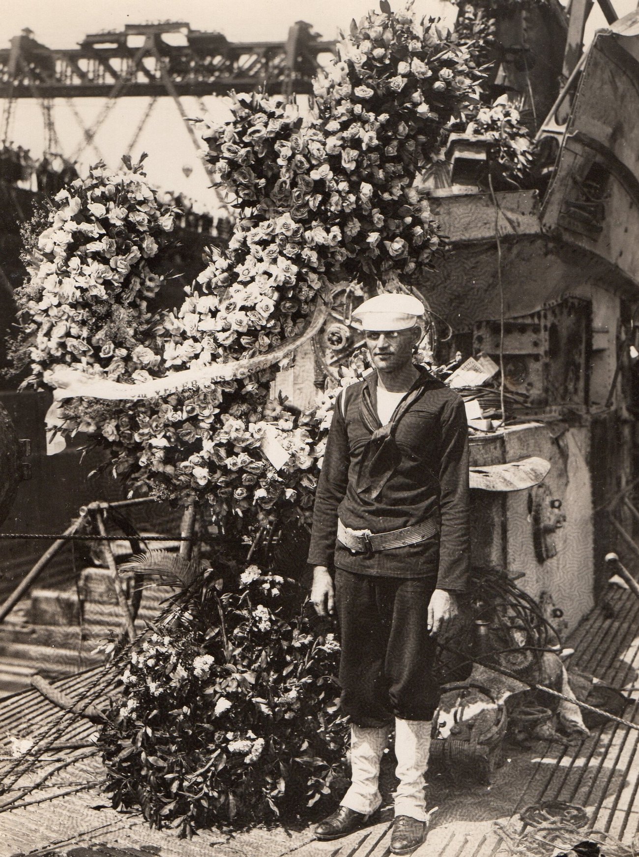 A sailor beside wreaths of flowers laid on the recovered S-51
